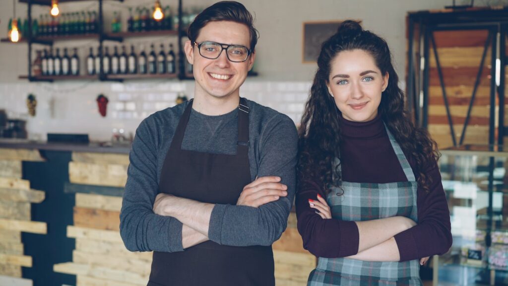 Two small-business owners standing together in their shop